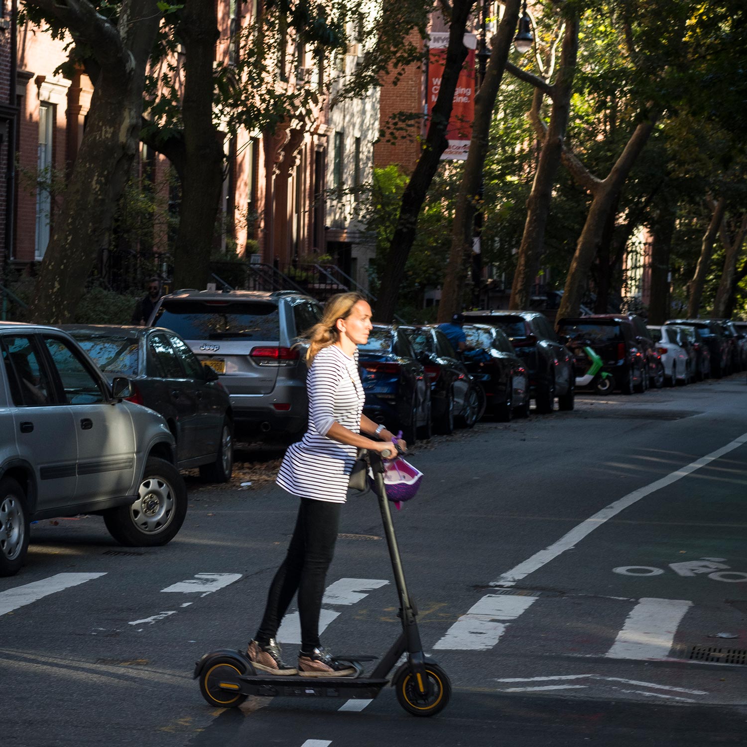 Woman on electric scooter in brownstone Brooklyn
